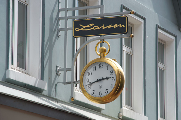 Goldenes Taschenuhr-Schild an der Fassade